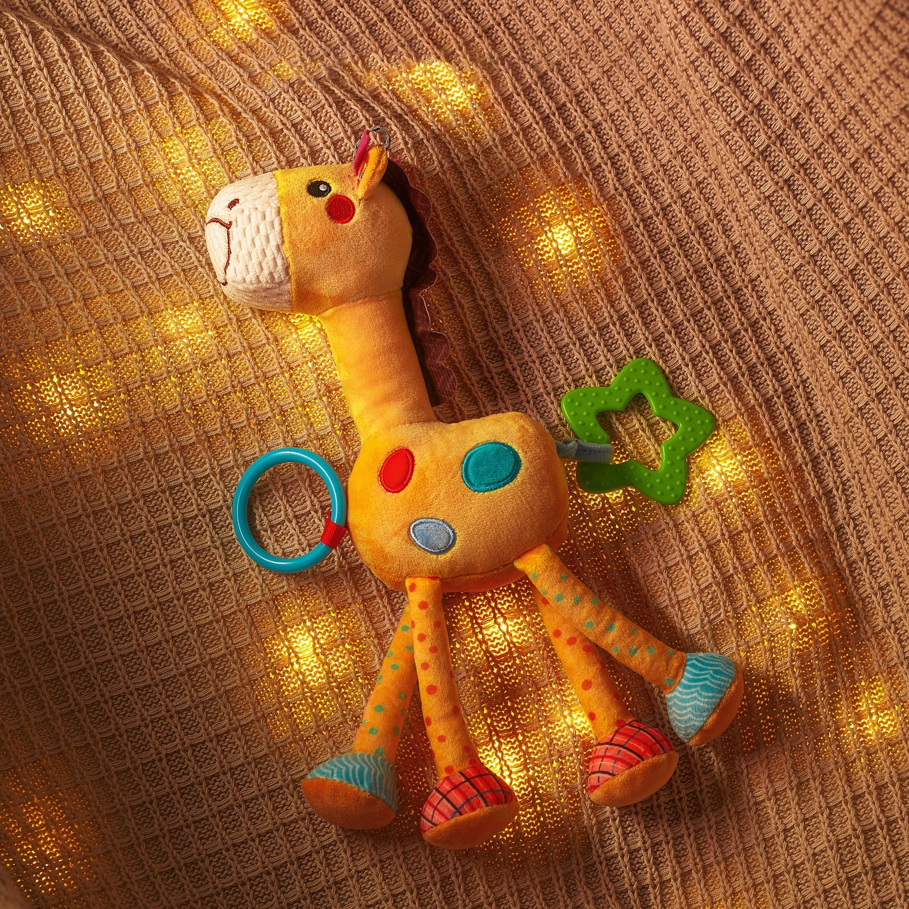 Yellow hanging baby rattle attached to a playpen